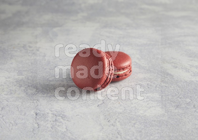 45º Shot of two Red Velvet macarons  on white  marble background