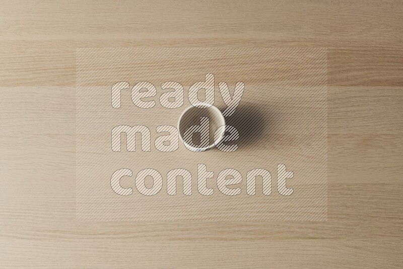A pottery cup on light wooden background
