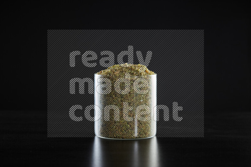 Freekeh in a glass jar on black background