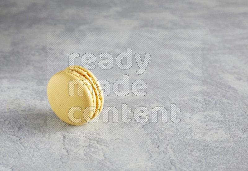 45º Shot of Yellow Vanilla macaron on white  marble background