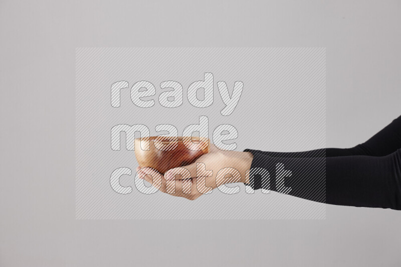 A woman in black abaya holding different wooden essentials in different positions