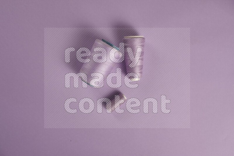 مجموعة من أدوات الخياطة والتفصيل أرجوانية اللون على خلفية أرجوانية