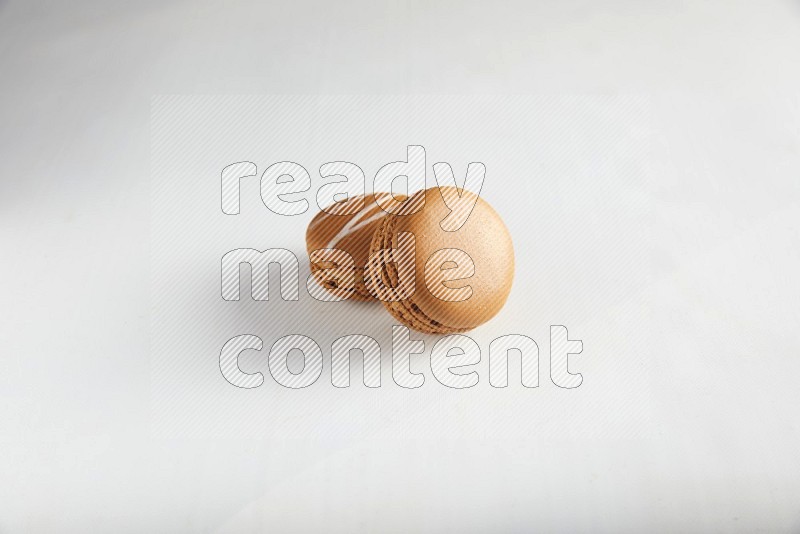 45º Shot of of two assorted Brown Irish Cream, and Brown Maple Taffy macarons  on white background