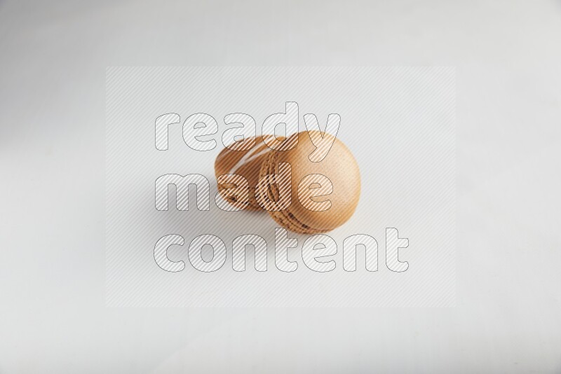 45º Shot of of two assorted Brown Irish Cream, and Brown Maple Taffy macarons  on white background