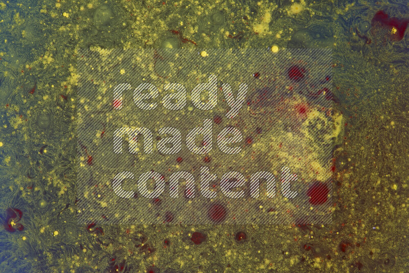 The image captures a dramatic splatter of yellow and red paints over an blue backdrop