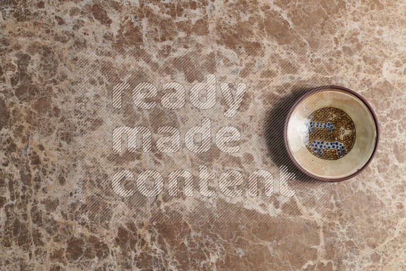 A decorative pottery plate on beige marble background