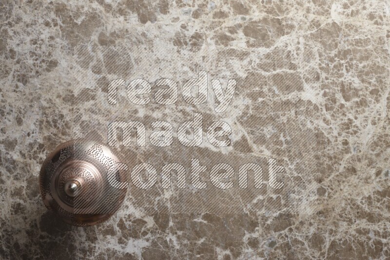 A lantern placed on a beige marble background