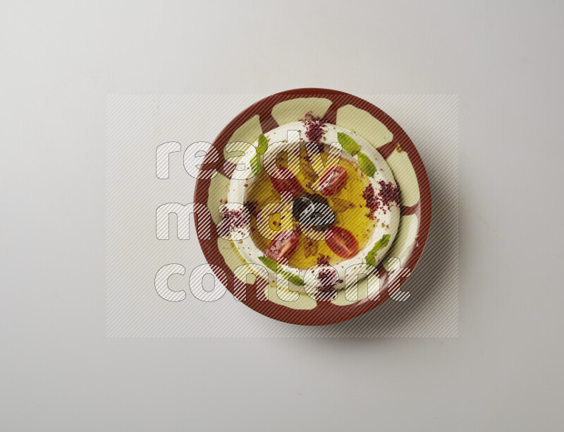 Lebnah garnished with Cherry tomato, mint & sumak  in a traditional plate on a white background