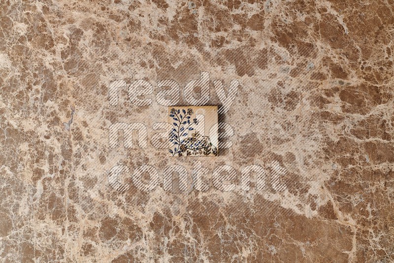 Top view shot of a pottery coaster tile on beige marble flooring