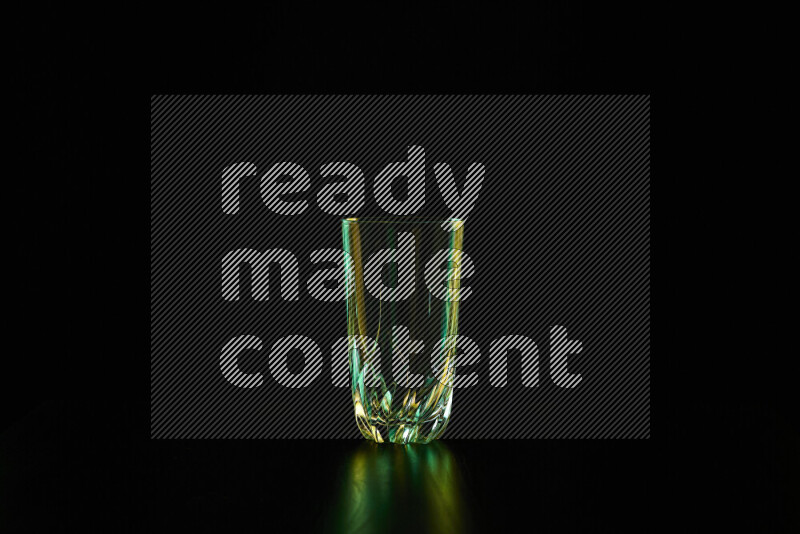 Glassware with rim light in green and yellow against black background