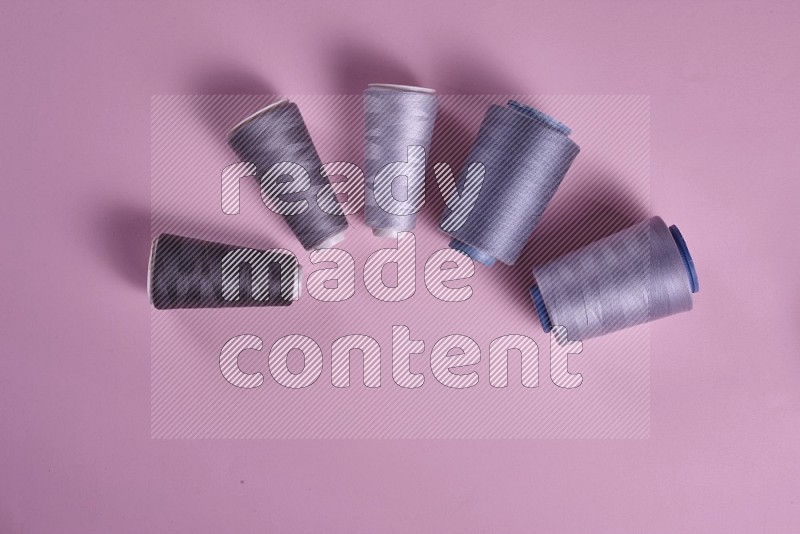 Grey sewing supplies on pink background