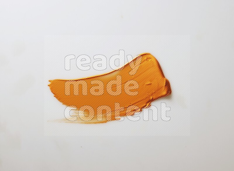 An orange single curved painting knife stroke on white background