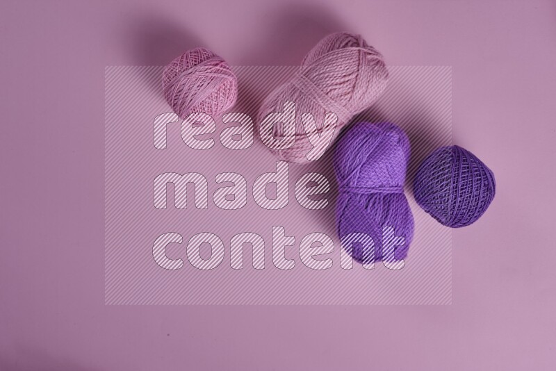 مجموعة من أدوات الخياطة والتفصيل أرجوانية وزهرية اللون على خلفية زهرية