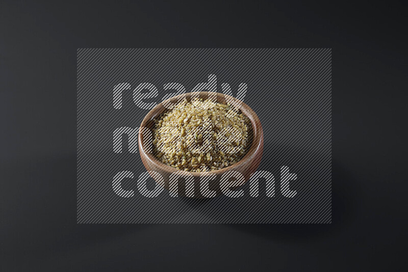 Coarse bulgur in a wooden bowl on grey background