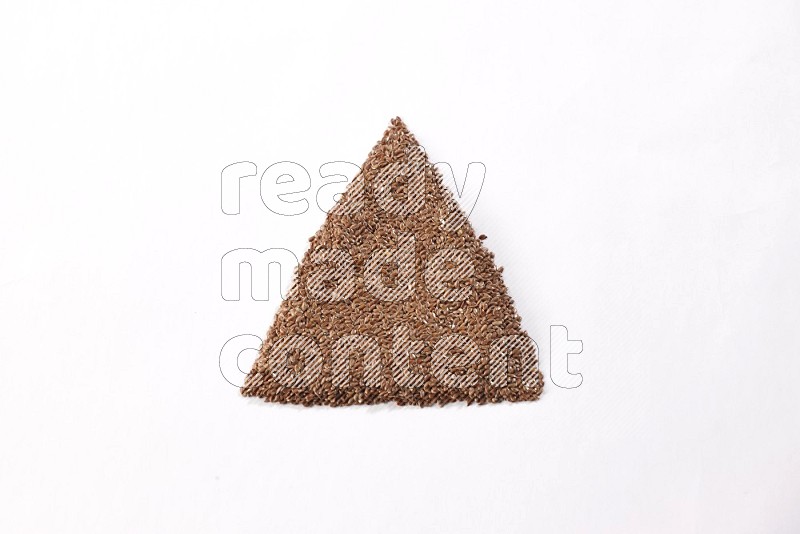 Flax seeds in a triangle shape on a white flooring