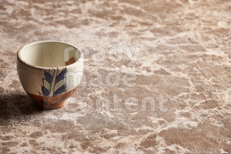 A decorative pottery bowl on beige marble background