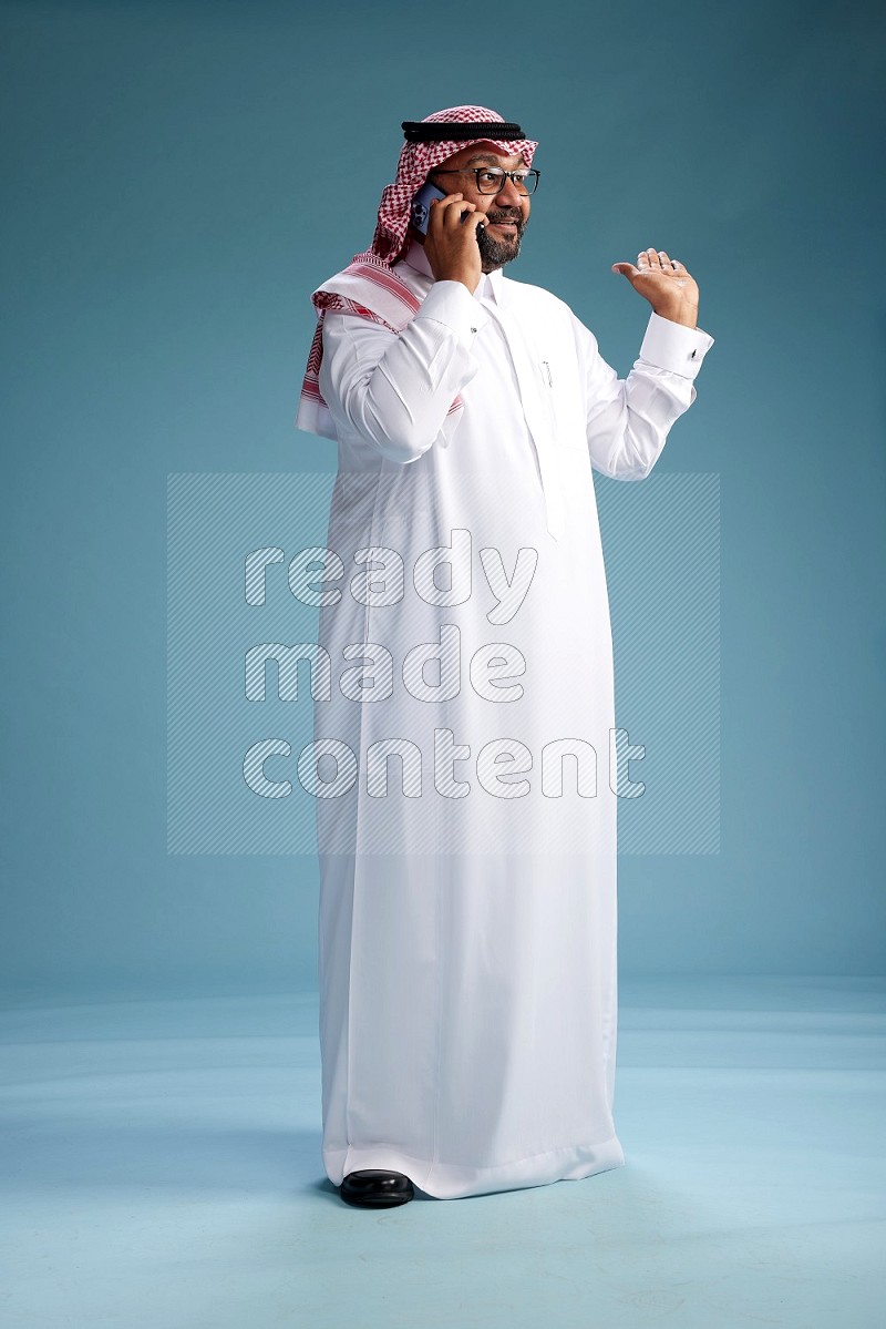 رجل سعودي يرتدي ثوب وشماغ يتحدث بالجوال