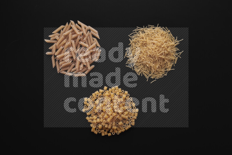 Different pasta types in bunches on black background