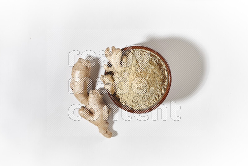 A brown pottery bowl full of ground ginger powder on white background