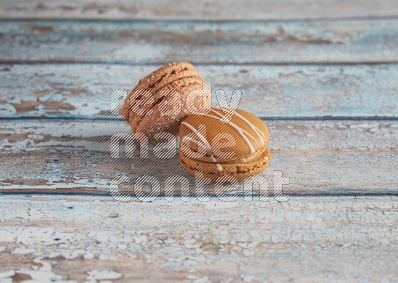 45º Shot of of two assorted Brown Irish Cream, and Brown Hazelnuts macarons  on light blue background