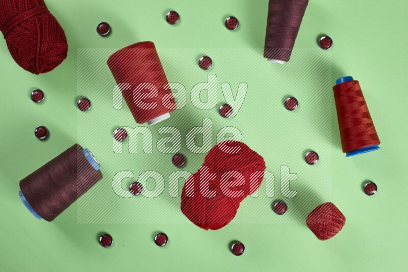 A red collection of sewing and tailoring tools arranged on a green background