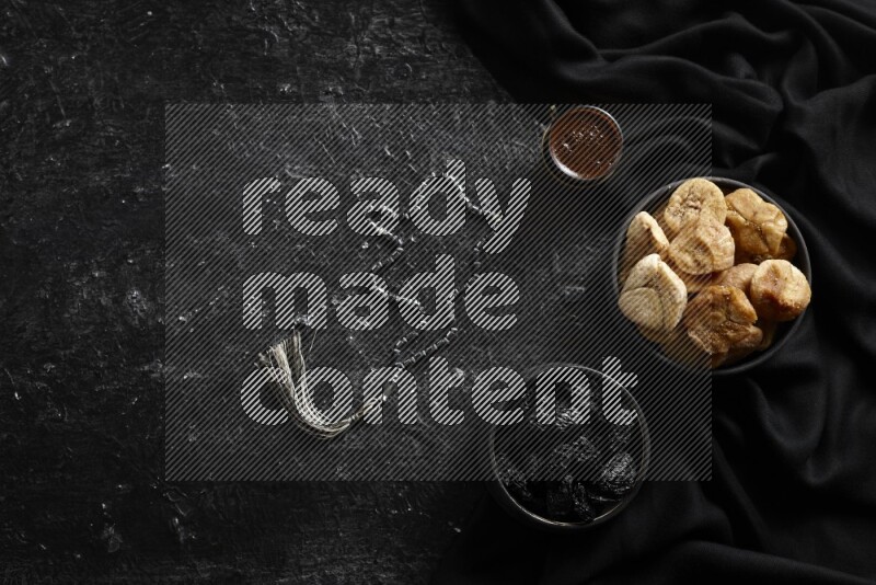 فواكه مجففة في أطباق فخارية مع القهوة علي خلفية سوداء خشبية