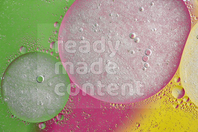 لقطات مقربة لفقاعات من الزيت على سطح الماء باللون الأصفر والأخضر والوردي