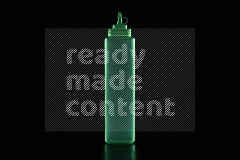 A squeeze bottle with colored rim light against black background