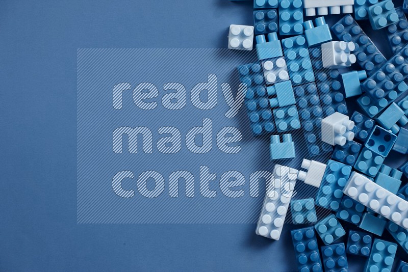 Blue plastic building blocks on blue background in top view (kids toys)
