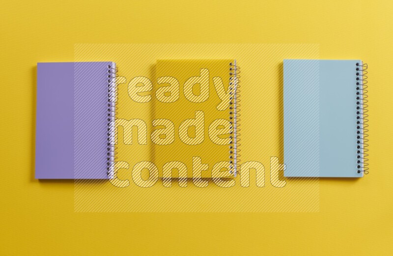 Multicolored notebooks on yellow background