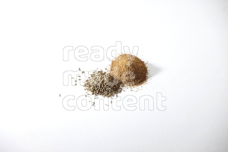 Cumin seeds and cumin powder on white flooring
