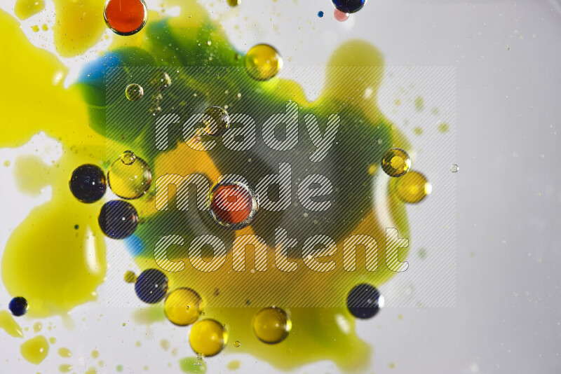 Close-ups of abstract red, blue, yellow and green watercolor drops on oil Surface on white background