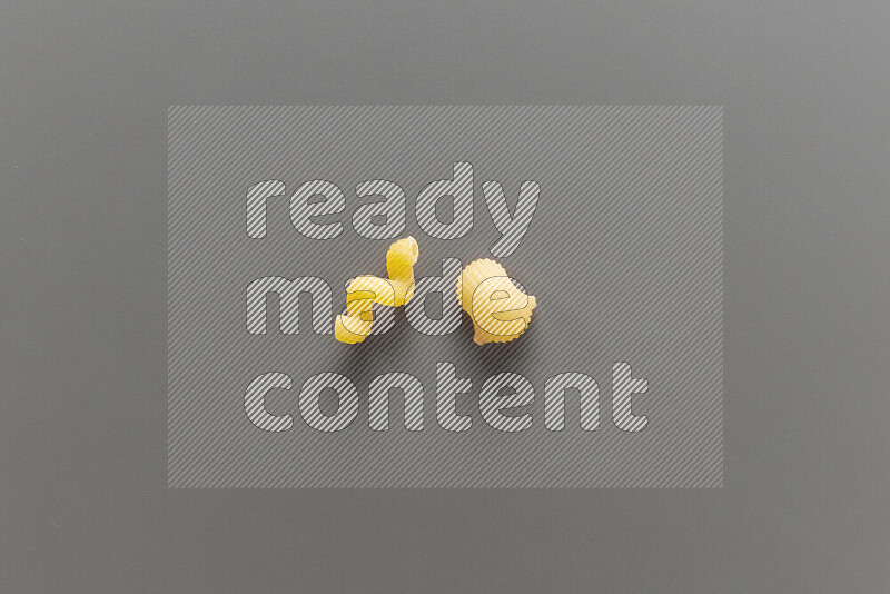 Twist pasta with other types of pasta on grey background