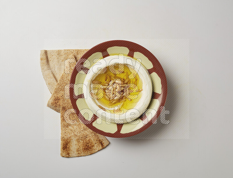 Lebnah garnished with pine nuts in a traditional plate on a white background