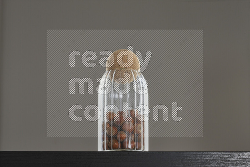 Hazelnuts in a glass jar on black background