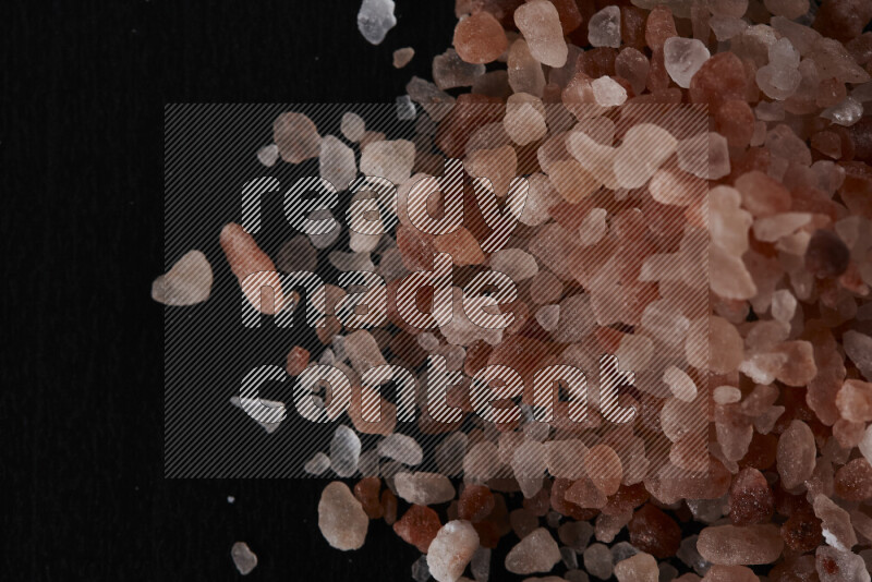 A bunch of coarse himalayan salt crystals on black background