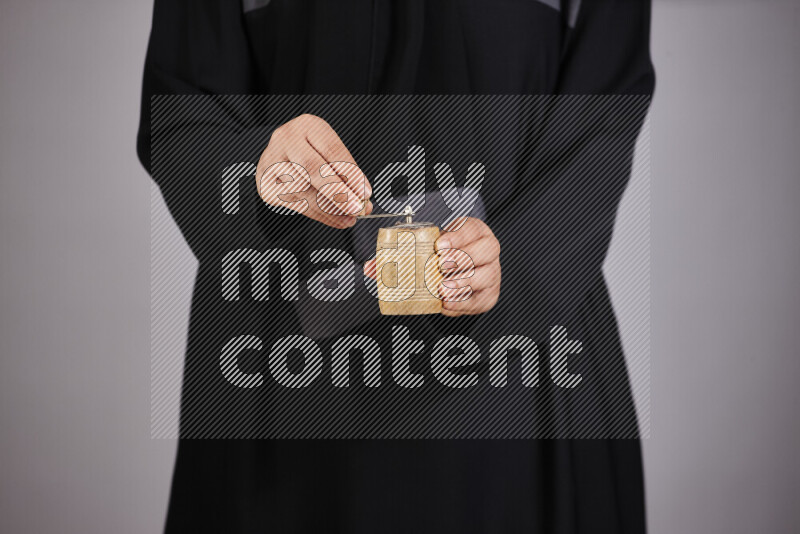 A woman in black abaya holding different wooden essentials in different positions