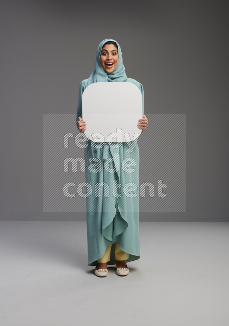 Saudi Woman wearing Abaya standing holding social media sign on Gray background