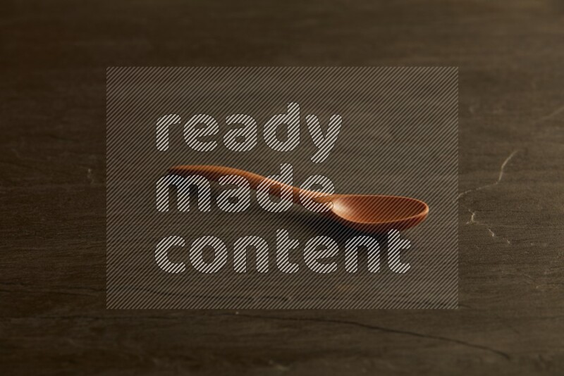 wooden spoon on black slate background