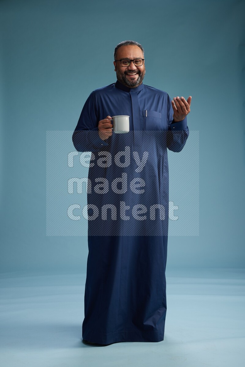 Saudi Man without shimag Standing drinking coffee on blue background