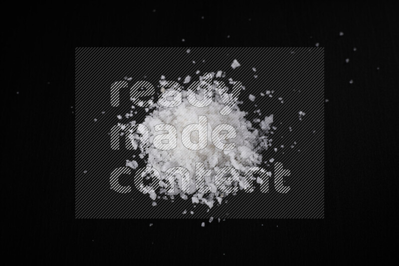 A bunch of coarse sea salt crystals on black background