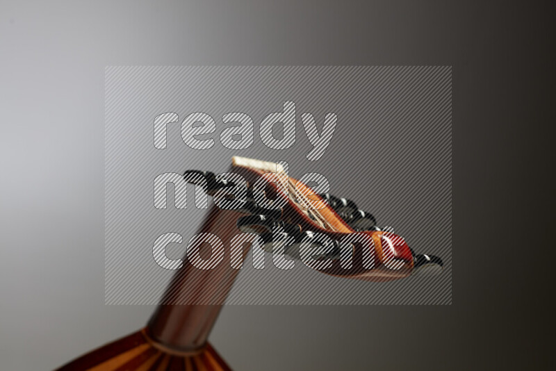 parts of a brown wooden Oud in a gray background