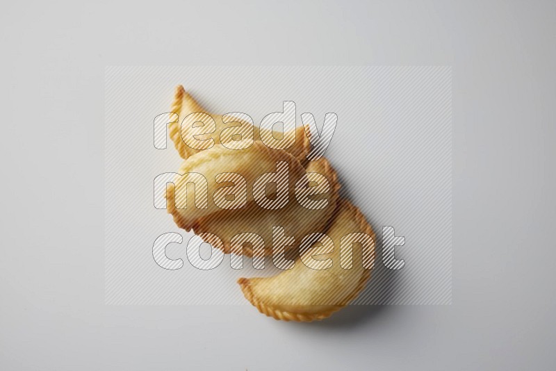 Four fried sambosa from a top angle on a white background