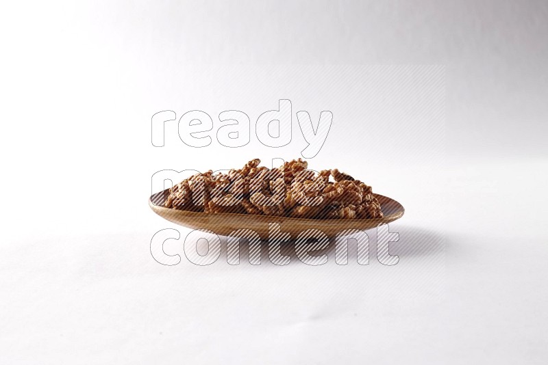 Walnuts in a wooden plate on white background