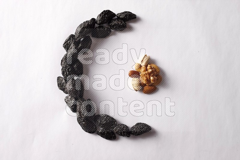 Dried plums in a crescent shape on white background