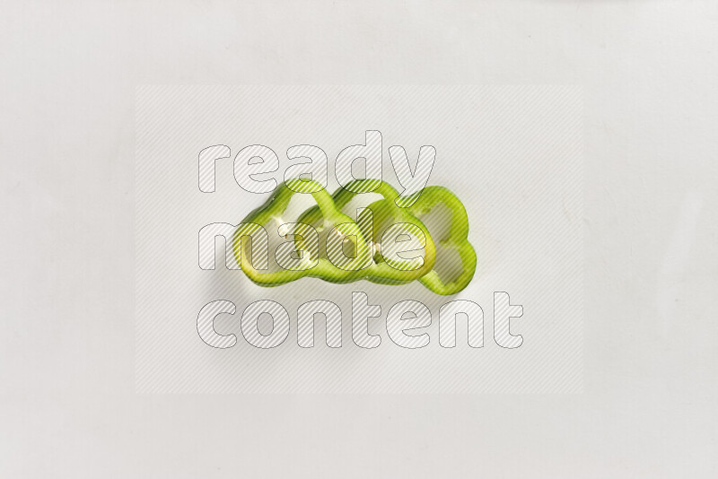 Green bell pepper slices on white background