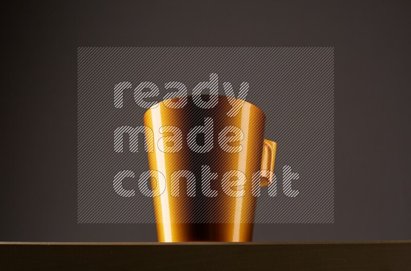 Low angle shot of a golden cup on grey background