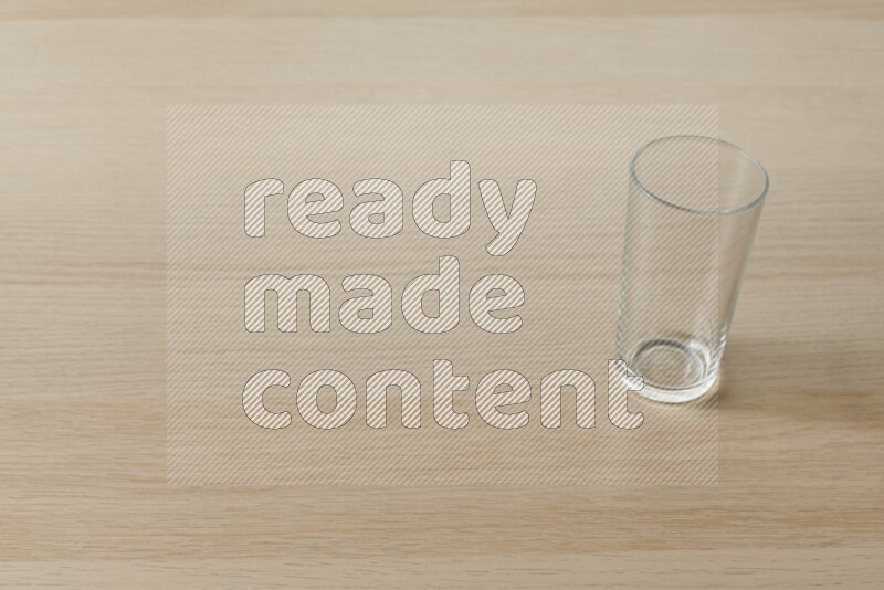 An empty glass cup on light wooden background