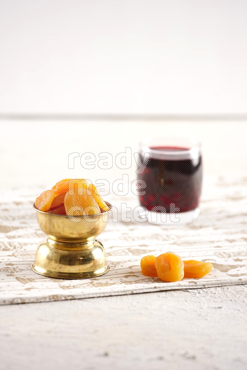 Dried fruits in a metal bowl with hibiscus in a light setup