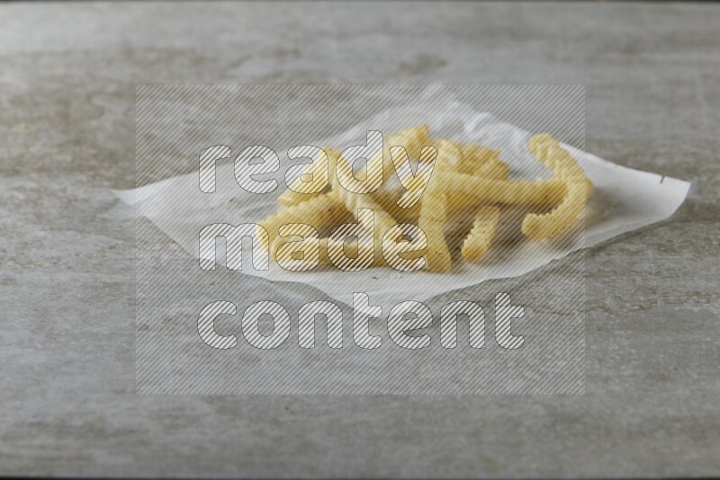 crinkle fries on parchment paper on grey textured counter top